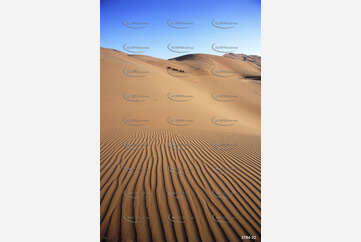 Sand waves, blue skies and a camel train Aerial Photography